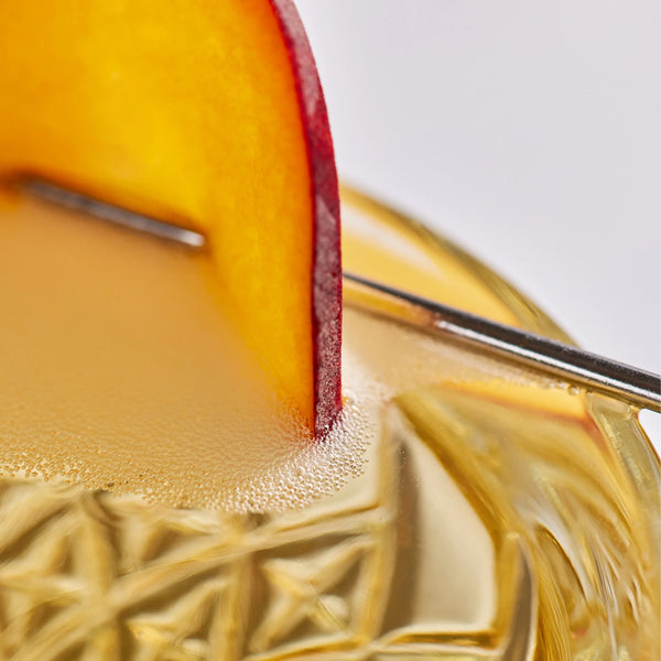 Close-up of a sliced peach on a Peach and Passionfruit GinFusion cocktail