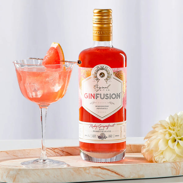 Bottle of Ruby Grapefruit GinFusion - Pink gin cocktail with small grapefruit on a tray