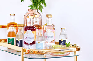The 5 must haves for your home bar cart - image of out GinFusions on top of a gold bar cart.