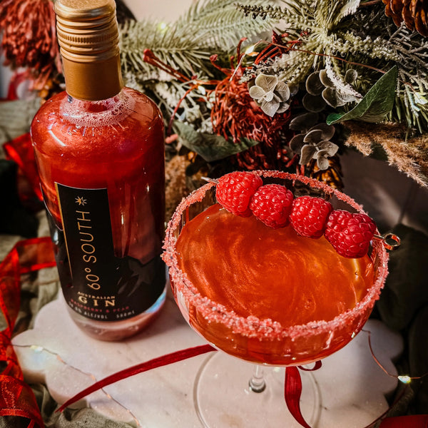 Red Raspberry and Pear 60º Degree South Gin and a cocktail with raspberries on a decorative surface.